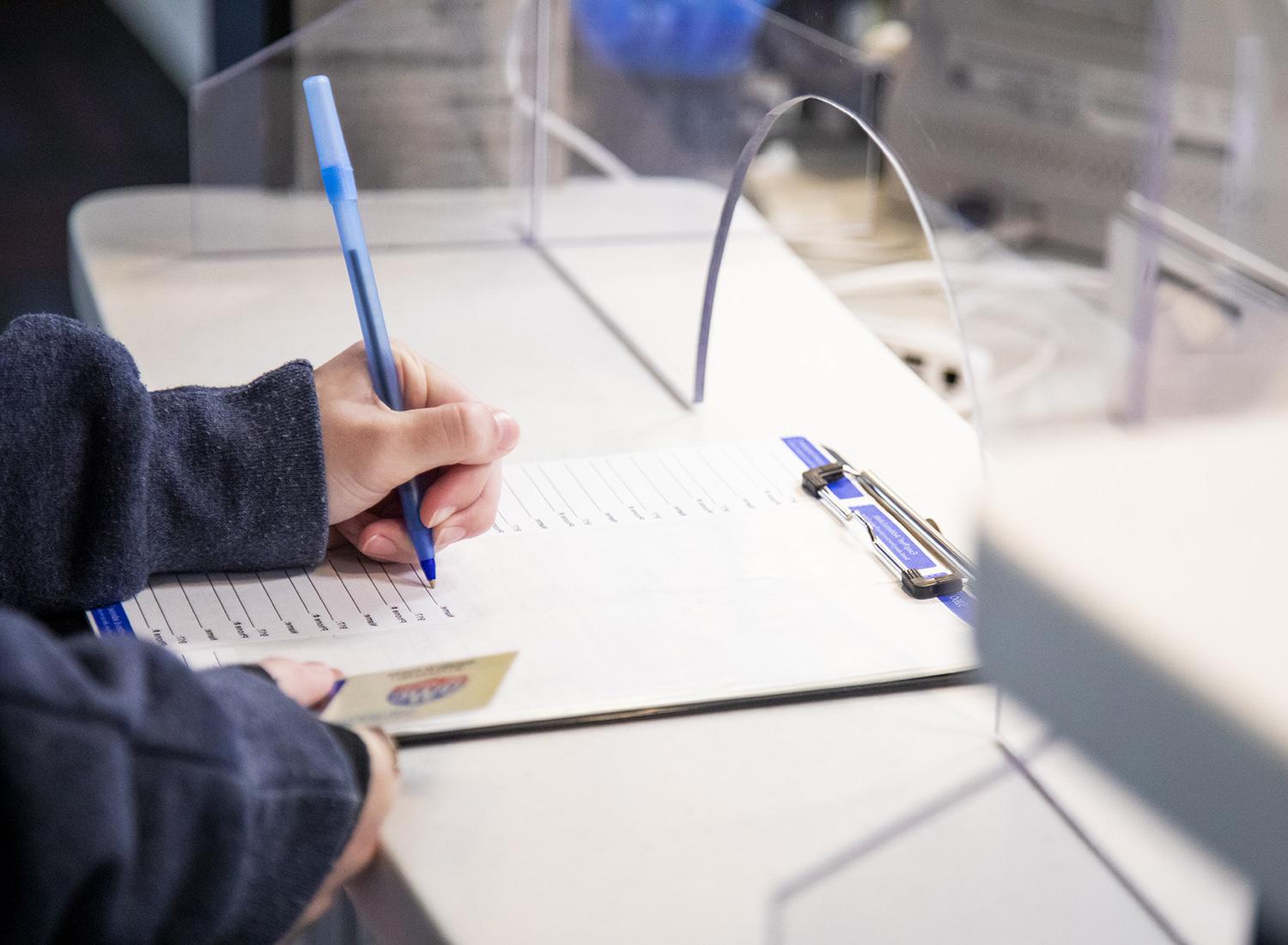 Student filling out paperwork at the 卫生服务 desk